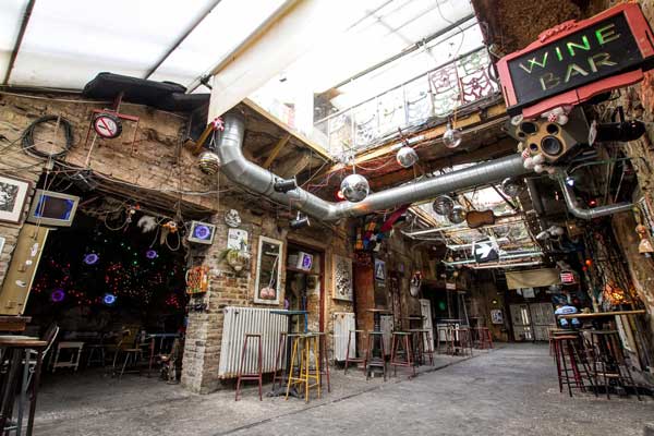 Outdoor seating area at Szimpla Kert, Budapest's famous ruin bar, with eclectic decorations and cozy ambiance.